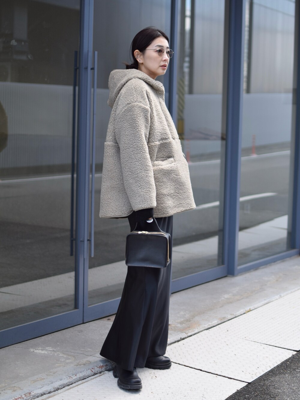 グリーン系のブルゾン、ブラック系のスカート、ブラック系のブーツを着用したレディースの冬コーディネートの4枚目の写真