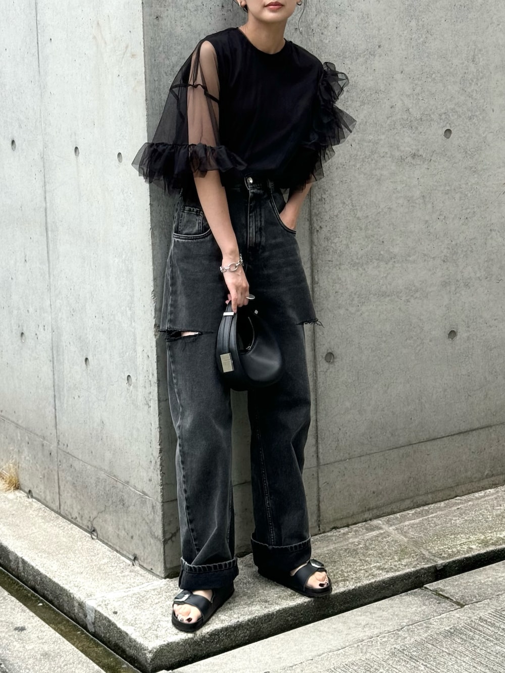 ブラック系のシャツ/ブラウス、ブラック系のデニムパンツ、ブラック系のハンドバッグを着用したレディースの夏コーディネートの2枚目の写真