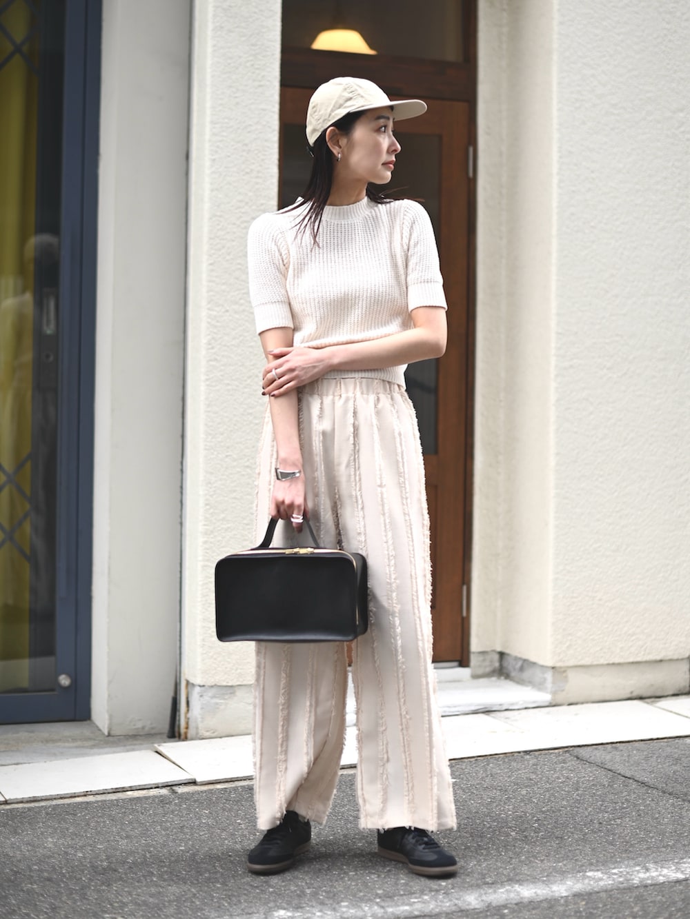 ホワイト系のニット/セーター、ホワイト系のその他パンツ、ブラック系のスニーカーを着用したレディースの春コーディネートの2枚目の写真