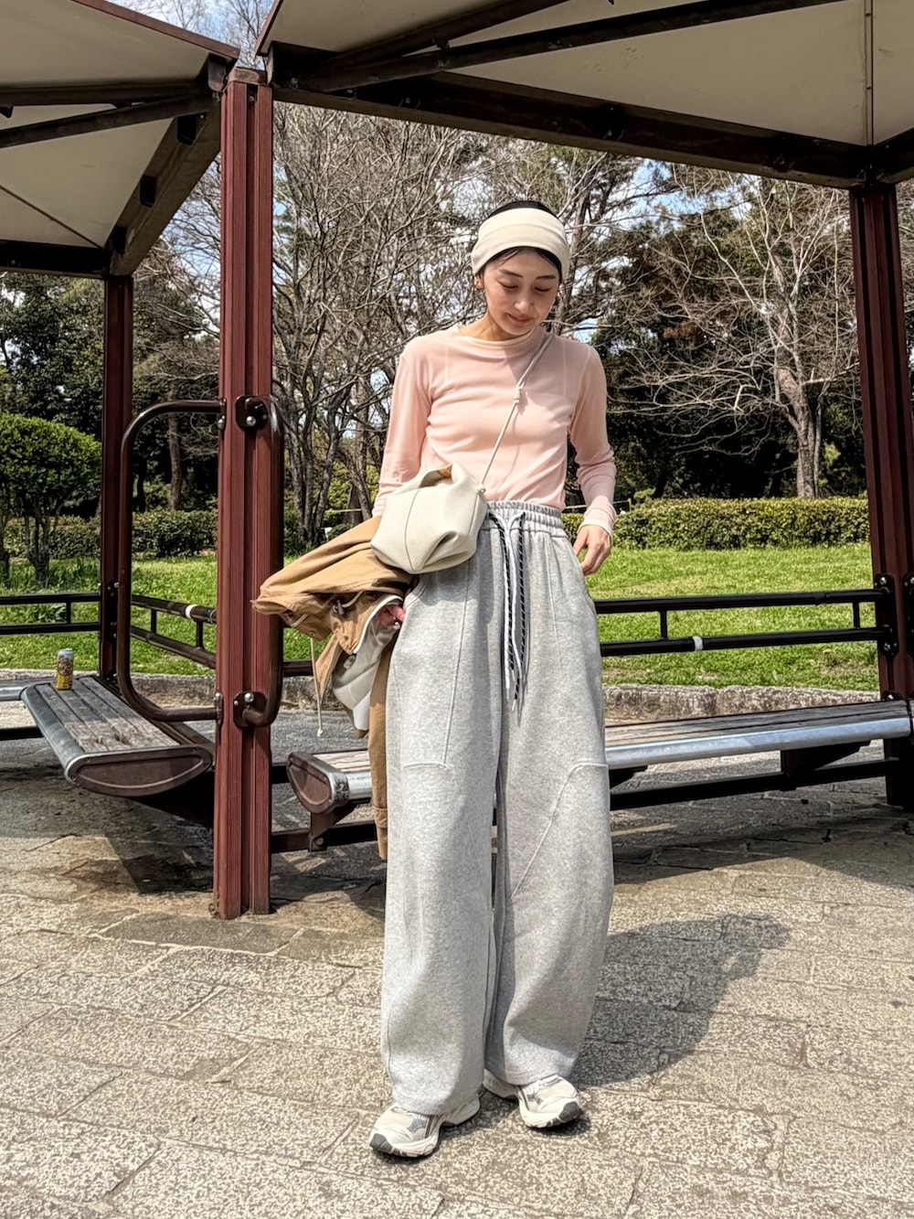 ピンク系のTシャツ/カットソー、グレー系のスウェットパンツ、ホワイト系のショルダーバッグを着用したレディースの春コーディネートの4枚目の写真