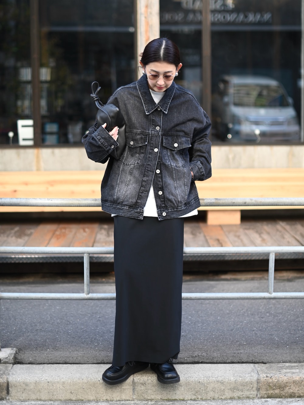 ブラック系のデニムジャケット、ブラック系のスカート、ブラック系のローファーを着用したレディースの春コーディネートの4枚目の写真