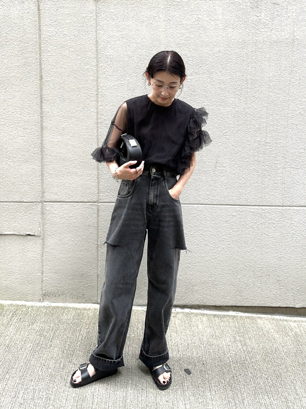 ブラック系のシャツ/ブラウス、ブラック系のデニムパンツ、ブラック系のハンドバッグを着用したレディースの夏コーディネートの4枚目の写真