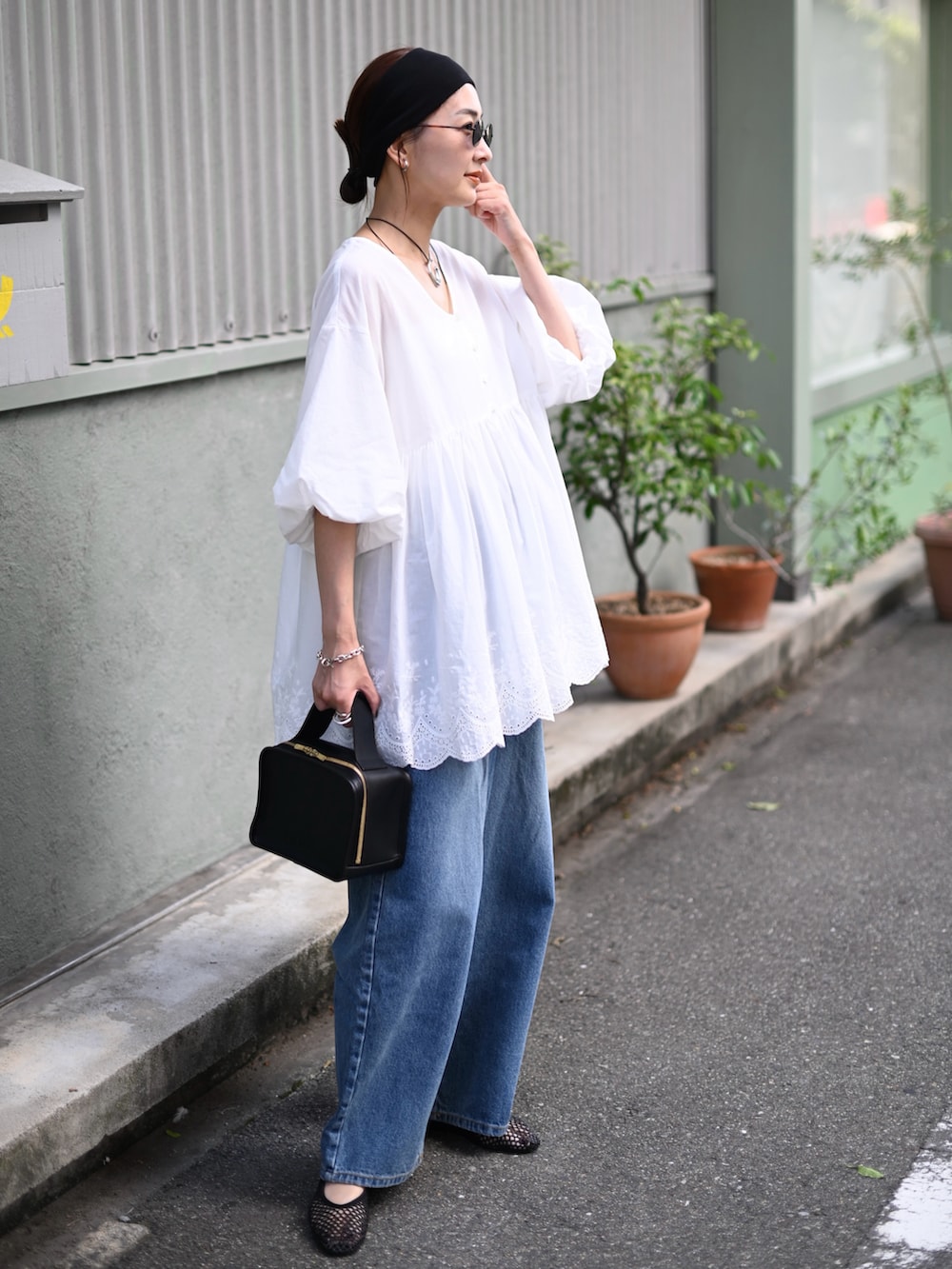 ホワイト系のシャツ/ブラウス、ブルー系のデニムパンツ、ブラック系のバレエシューズを着用したレディースの夏コーディネートの5枚目の写真