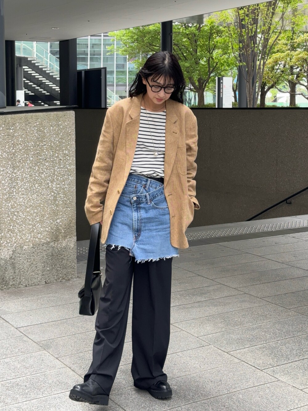 ブラック系のTシャツ/カットソー、ブラック系のスラックス、ブラック系のブーツを着用したレディースの春コーディネートの3枚目の写真