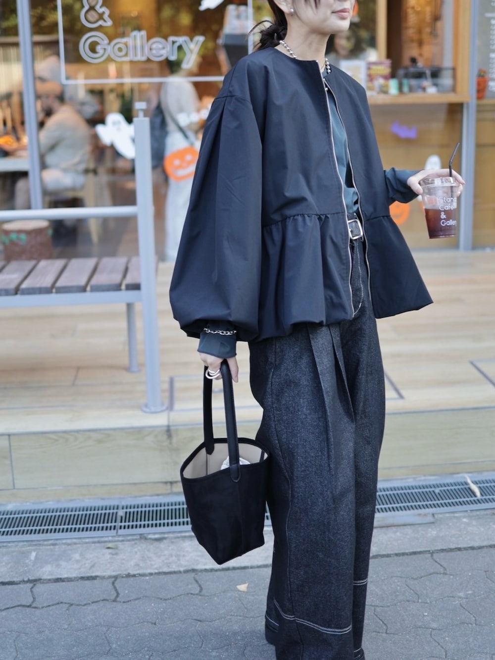 ブラック系のブルゾン、グレー系のTシャツ/カットソー、ブラック系のデニムパンツを着用したレディースの秋コーディネートの4枚目の写真