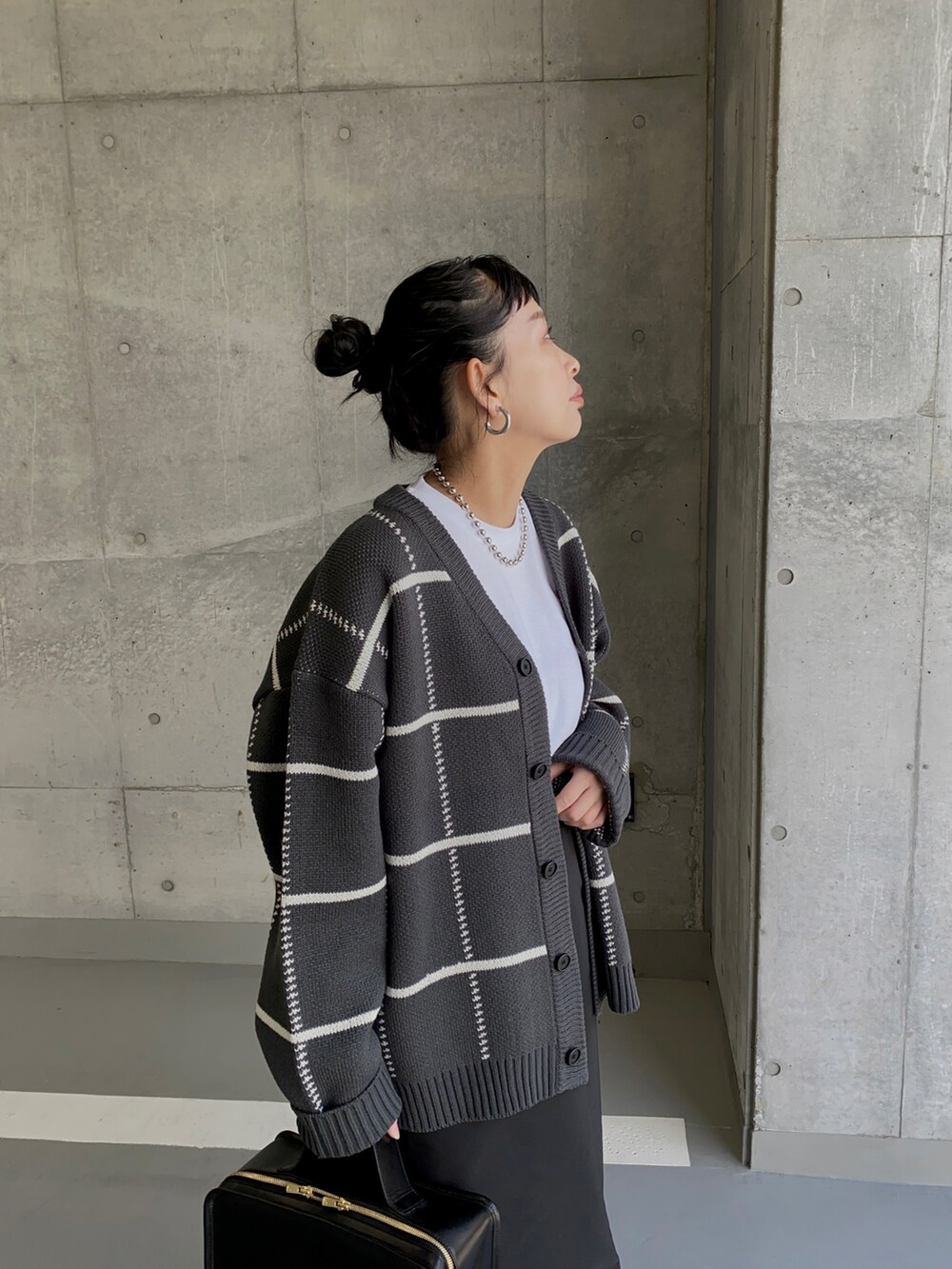 グレー系のカーディガン/ボレロ、ブラック系のスカート、ブラック系のブーツを着用したレディースの冬コーディネートの2枚目の写真