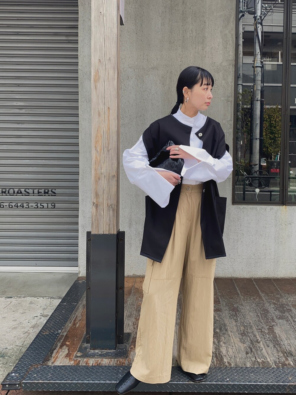 ブラック系のベスト、ホワイト系のシャツ/ブラウス、ベージュ系のカーゴパンツを着用したレディースの春コーディネートの3枚目の写真