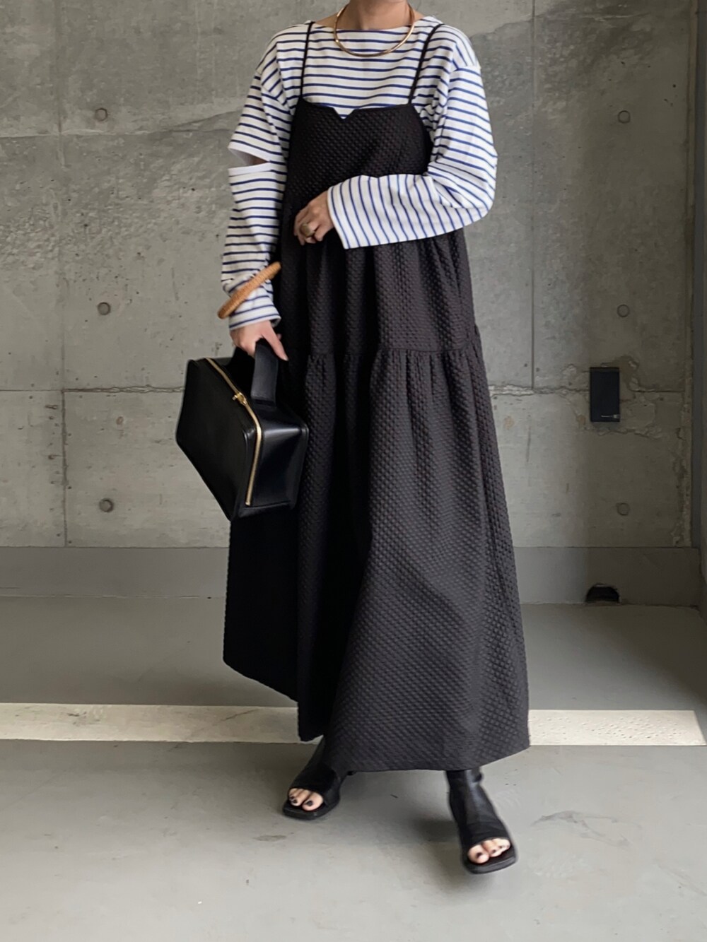 ブルー系のTシャツ/カットソー、ブラック系のワンピース、ゴールド系のネックレスを着用したレディースの春コーディネートの2枚目の写真