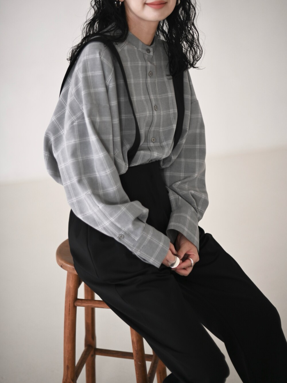 グレー系のシャツ/ブラウス、ブラック系のスラックス、ブラック系のブーツを着用したレディースの冬コーディネートの2枚目の写真