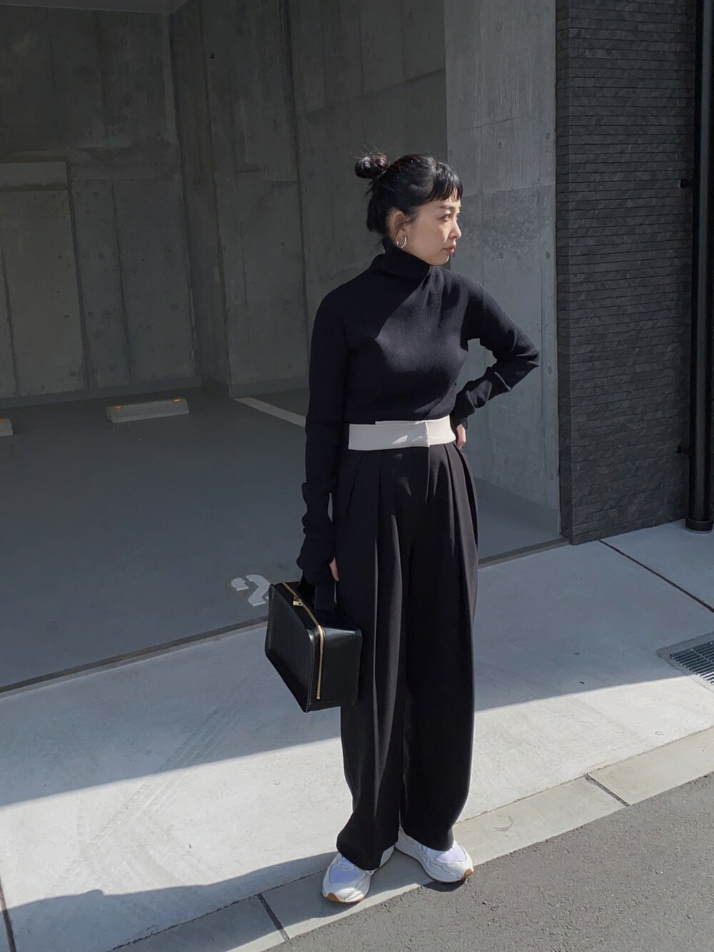 ブラック系のニット/セーター、ブラック系のパンツ、ホワイト系のスニーカーを着用したレディースの冬コーディネートの2枚目の写真