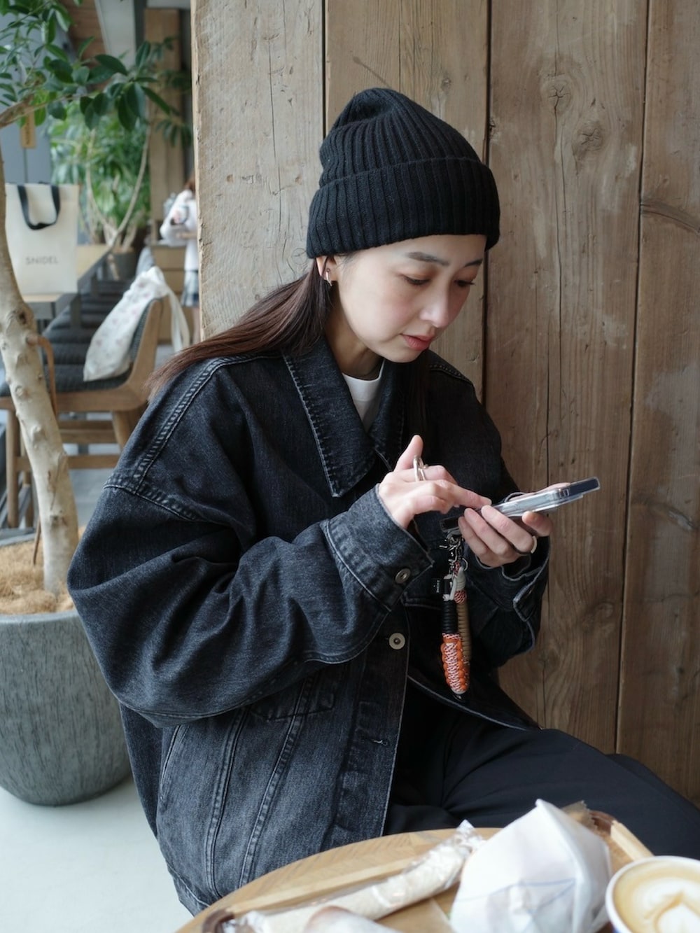 ブラック系のデニムジャケット、ブラック系のスラックス、ブラック系のローファーを着用したレディースの冬コーディネートの5枚目の写真