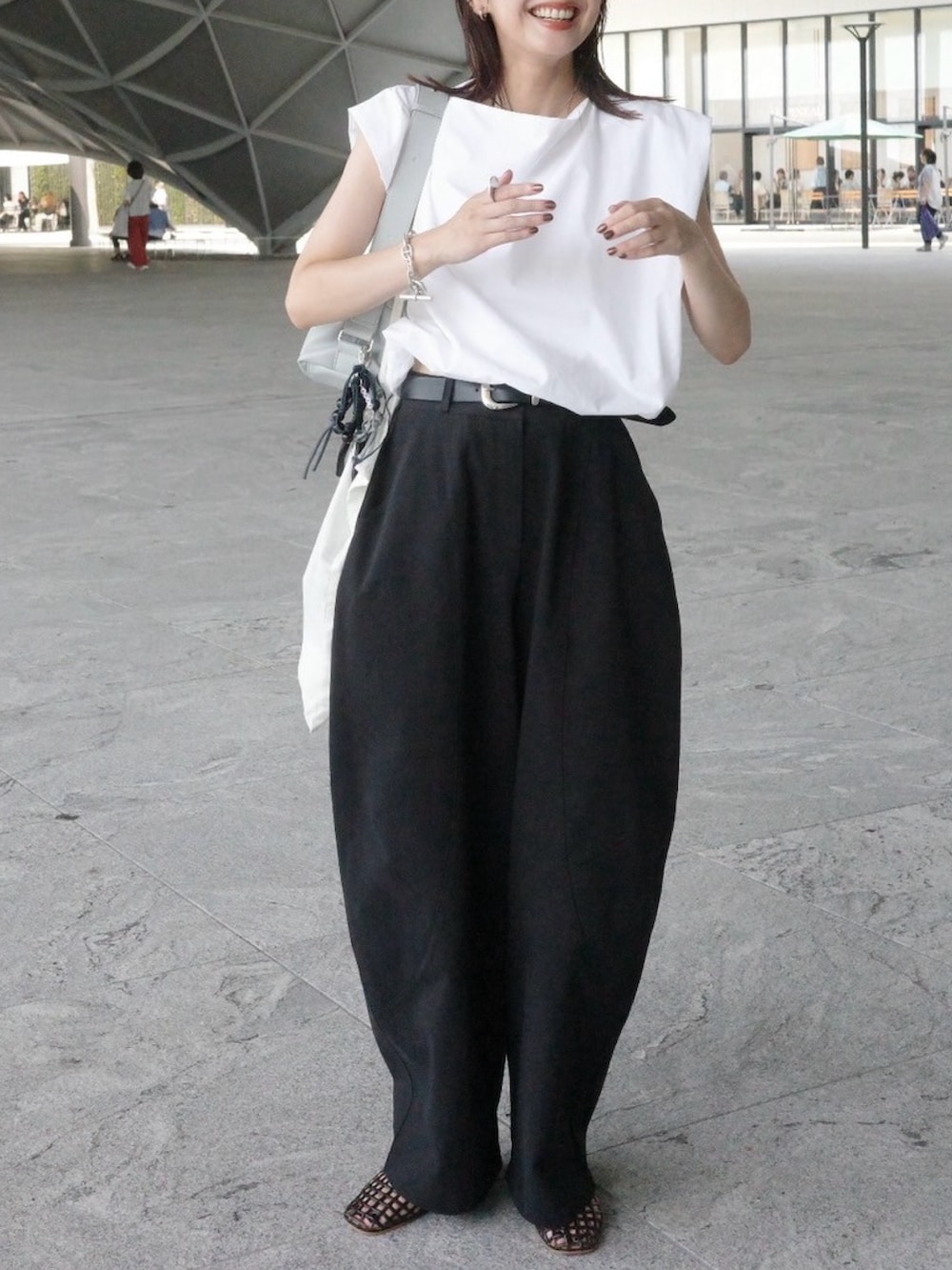 ホワイト系のシャツ/ブラウス、ブラウン系のバレエシューズ、ブラック系のチノパンツを着用したレディースの夏コーディネートの2枚目の写真