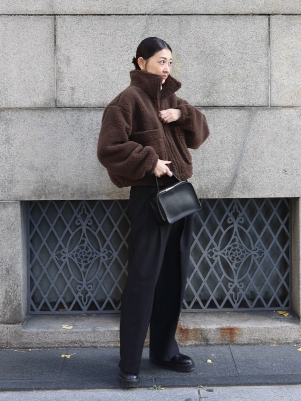 ブラウン系のその他アウター、ブラック系のスラックス、ブラック系のブーツを着用したレディースの冬コーディネートの2枚目の写真