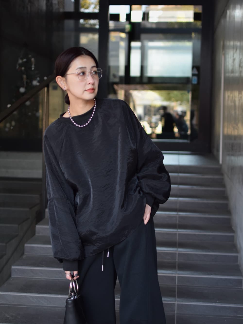 ブラック系のTシャツ/カットソー、ブラック系のスウェットパンツ、シルバー系のスニーカーを着用したレディースの春コーディネートの3枚目の写真