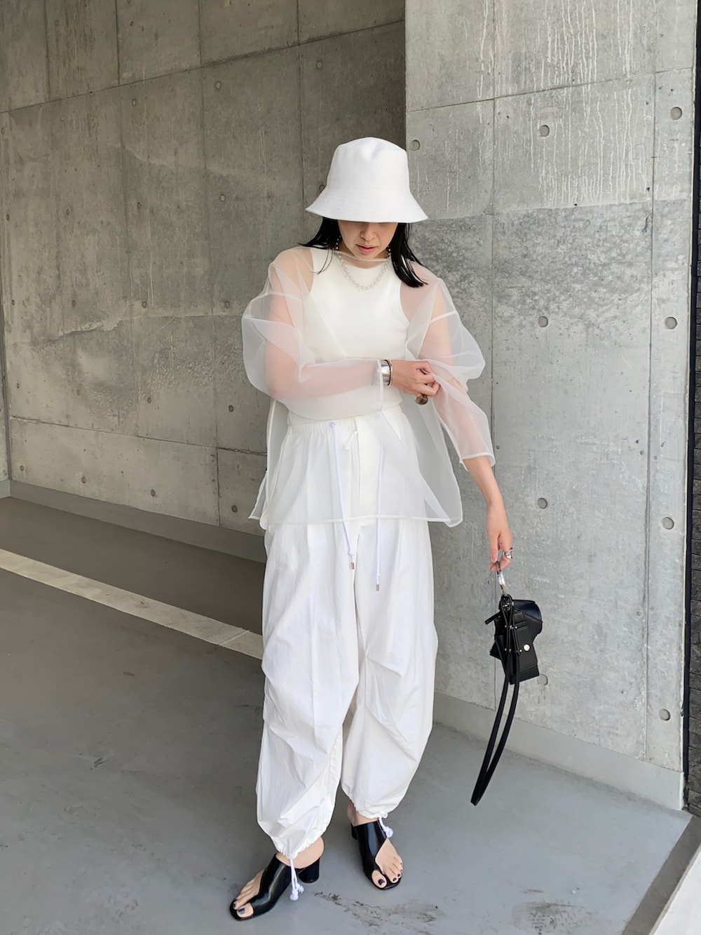 ホワイト系のその他パンツ、ブラック系のショルダーバッグ、ホワイト系のシャツ/ブラウスを着用したレディースの夏コーディネートの4枚目の写真