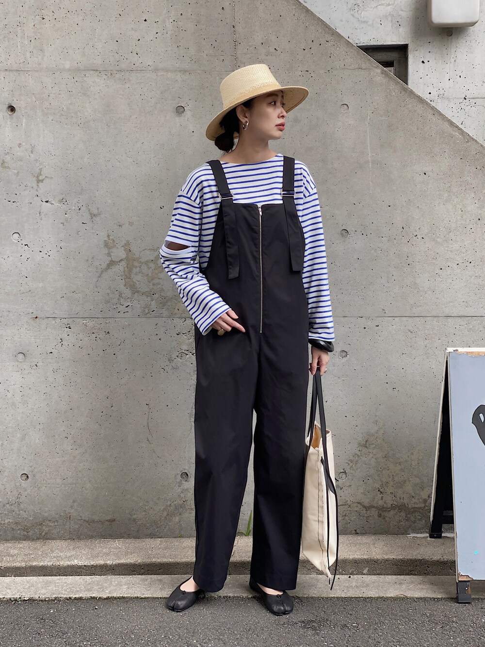 ブラック系のバレエシューズ、ブルー系のTシャツ/カットソー、ブラック系のサロペット/オーバーオールを着用したレディースの春コーディネートの2枚目の写真
