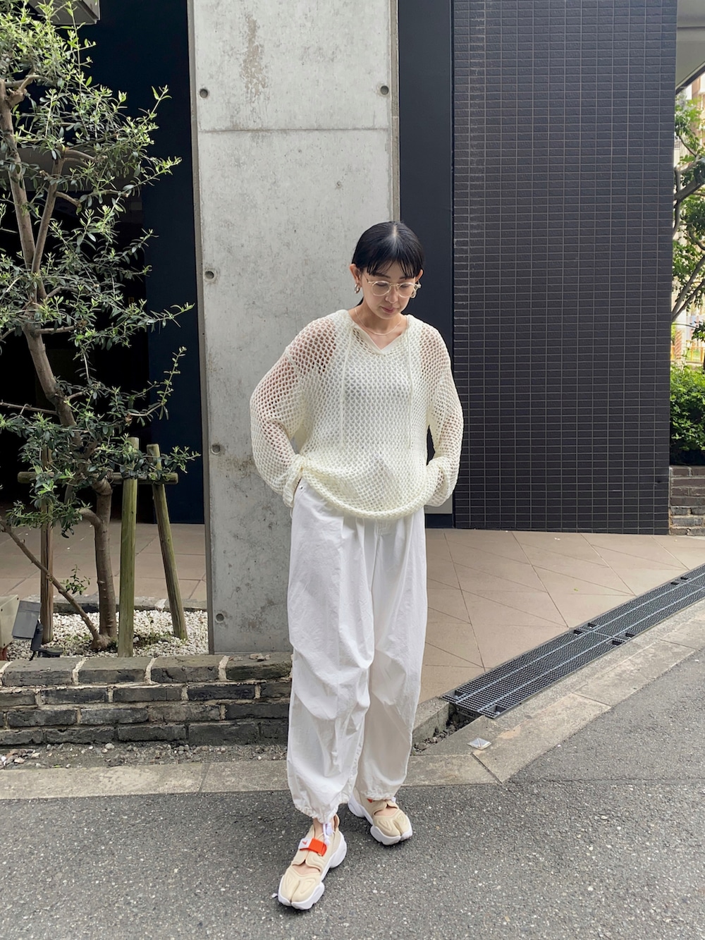 ホワイト系のニット/セーター、ホワイト系のその他パンツ、その他のスニーカーを着用したレディースの夏コーディネートの5枚目の写真