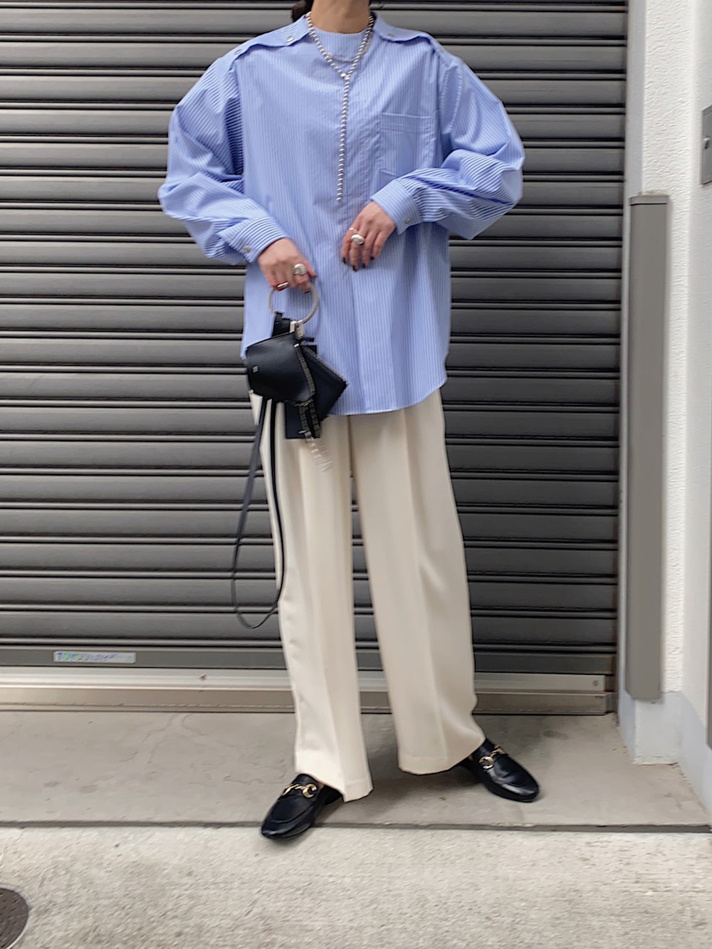 ブルー系のシャツ/ブラウス、ブラック系のショルダーバッグ、ブラック系のローファーを着用したレディースの春コーディネートの3枚目の写真