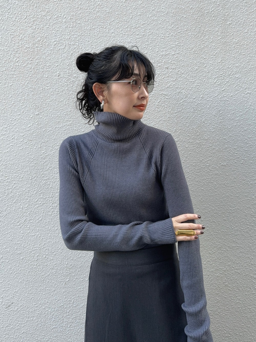 グレー系のニット/セーター、グレー系のスラックス、ブラック系のライダースジャケットを着用したレディースの秋コーディネートの2枚目の写真