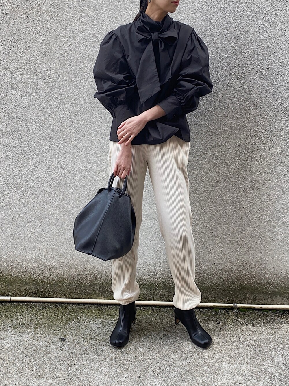 ブラック系のシャツ/ブラウス、ホワイト系のその他パンツ、ブラック系のハンドバッグを着用したレディースの冬コーディネートの2枚目の写真
