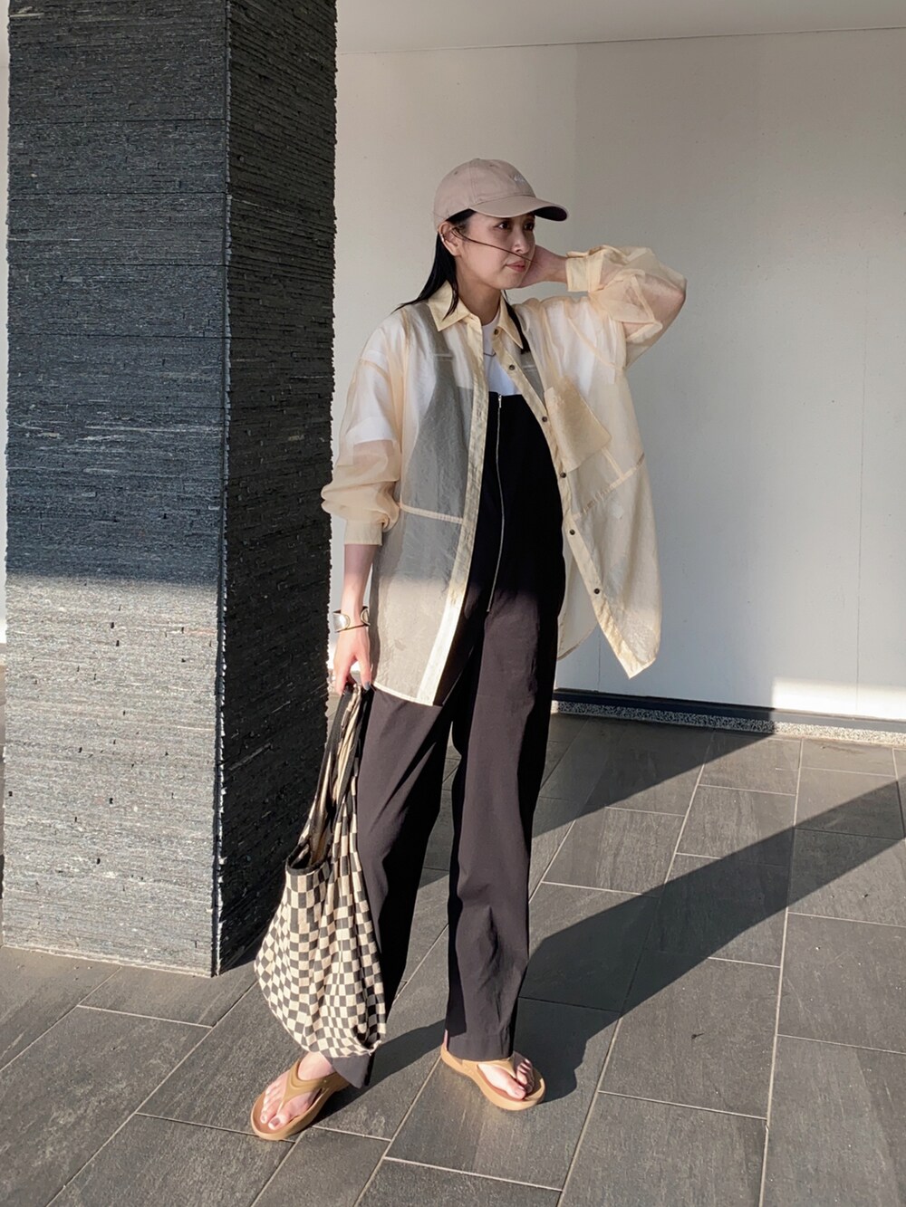 ブラック系のサロペット/オーバーオール、ベージュ系のサンダル、ホワイト系のTシャツ/カットソーを着用したレディースの夏コーディネートの4枚目の写真