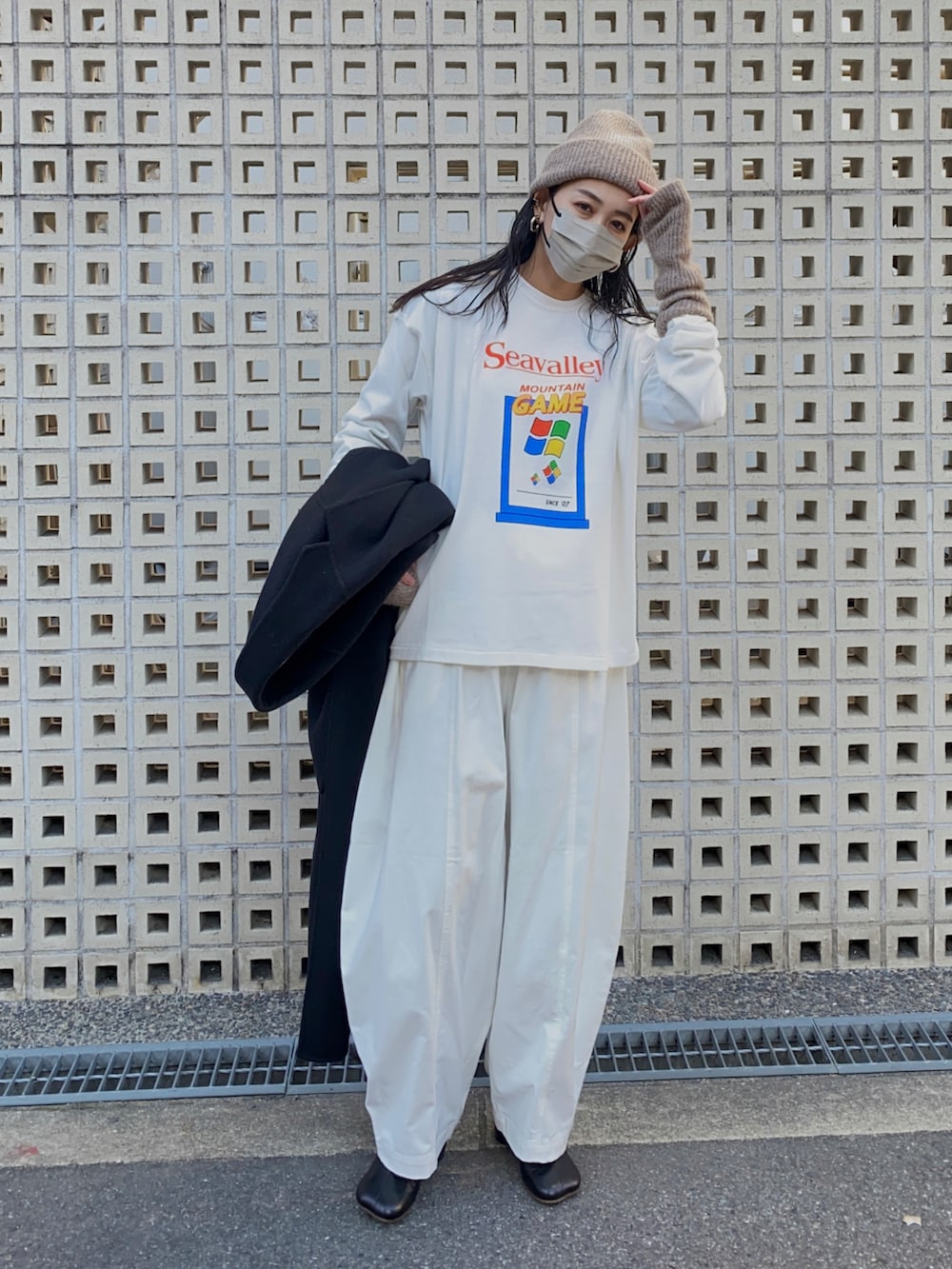 ホワイト系のTシャツ/カットソー、ホワイト系のチノパンツ、ブラック系のブーツを着用したレディースの冬コーディネートの4枚目の写真