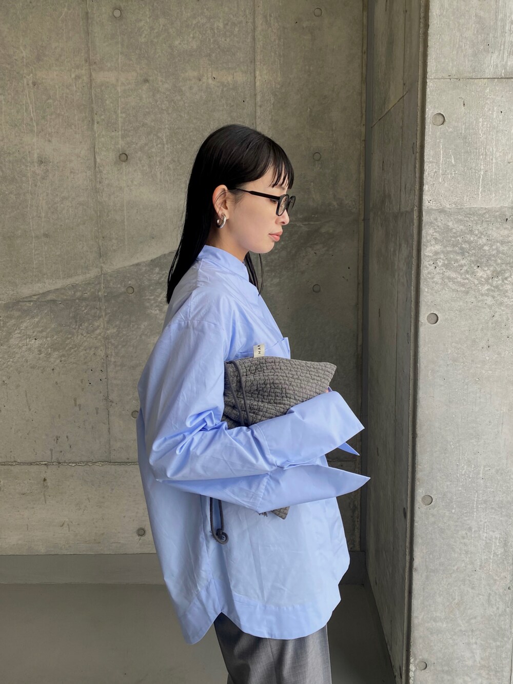 グレー系のスラックス、その他のスニーカー、ブルー系のシャツ/ブラウスを着用したレディースの冬コーディネートの3枚目の写真