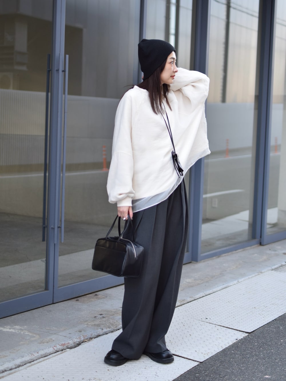ホワイト系のTシャツ/カットソー、グレー系のその他パンツ、ブラック系のボストンバッグを着用したレディースの冬コーディネートの5枚目の写真