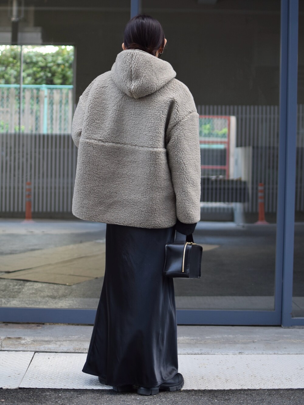 グリーン系のブルゾン、ブラック系のスカート、ブラック系のブーツを着用したレディースの冬コーディネートの3枚目の写真