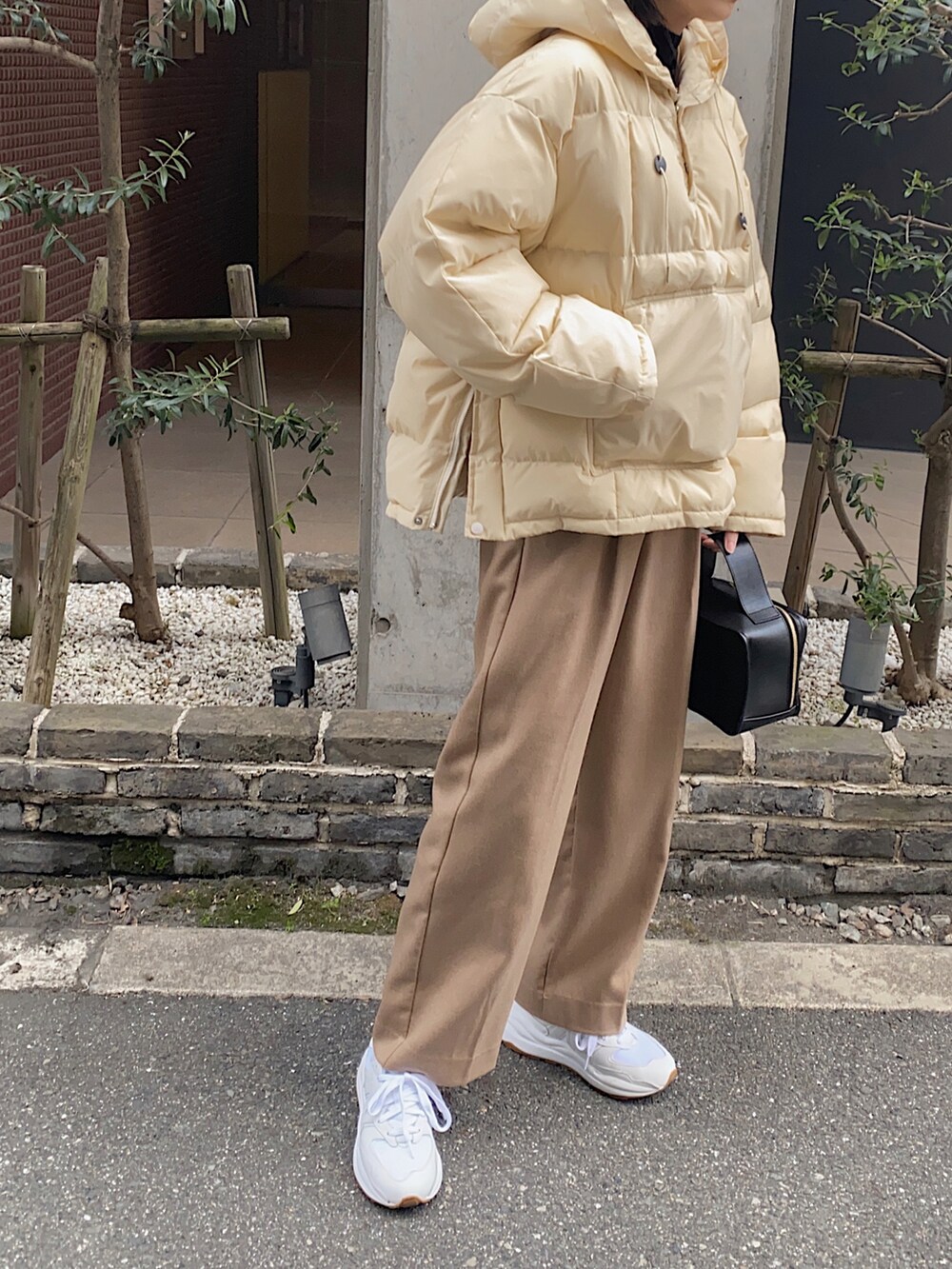 ベージュ系のダウンジャケット/コート、ベージュ系のその他パンツ、ホワイト系のスニーカーを着用したレディースの冬コーディネートの3枚目の写真