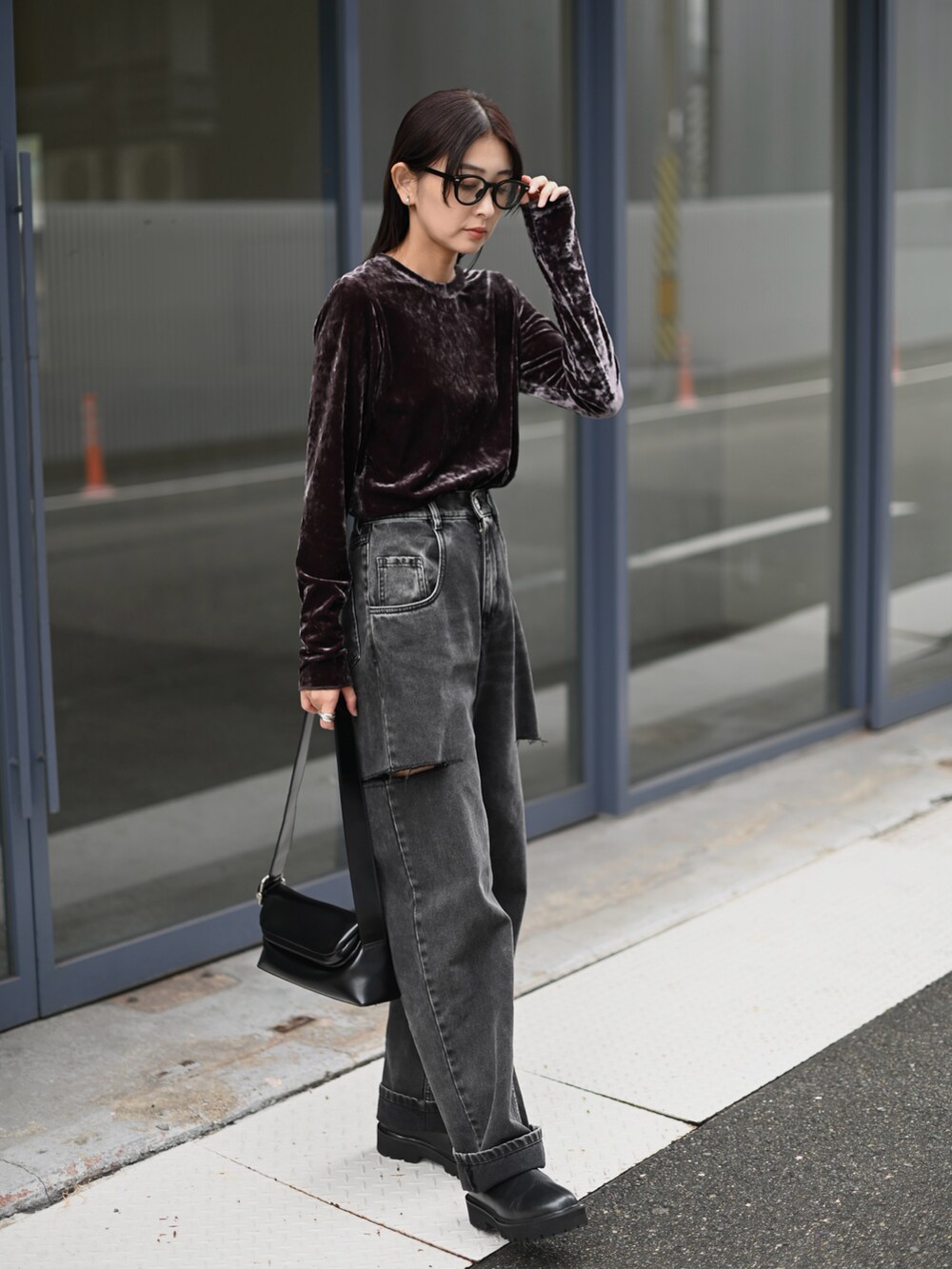 グレー系のTシャツ/カットソー、ブラック系のデニムパンツ、ブラック系のブーツを着用したレディースの秋コーディネートの4枚目の写真