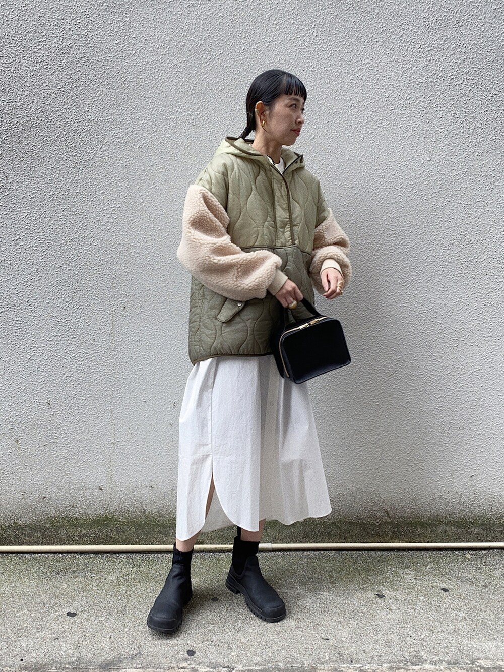 ホワイト系のシャツワンピース、ブラック系のブーツ、グリーン系のダウンジャケット/コートを着用したレディースの秋コーディネートの3枚目の写真