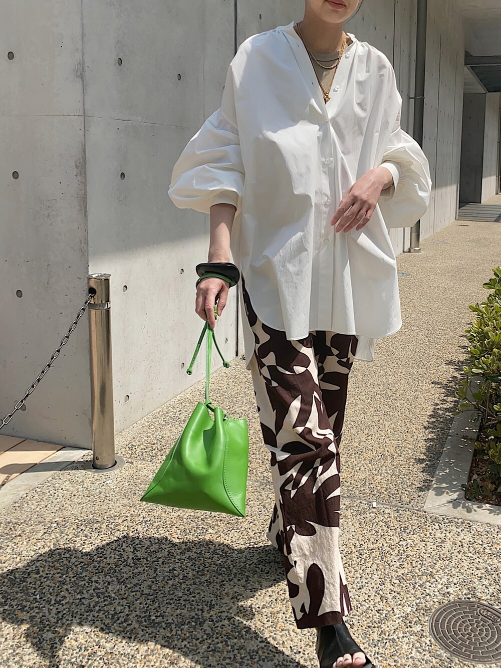 ホワイト系のシャツ/ブラウス、グリーン系のハンドバッグ、ブラック系のブレスレットを着用したレディースの春コーディネートの2枚目の写真