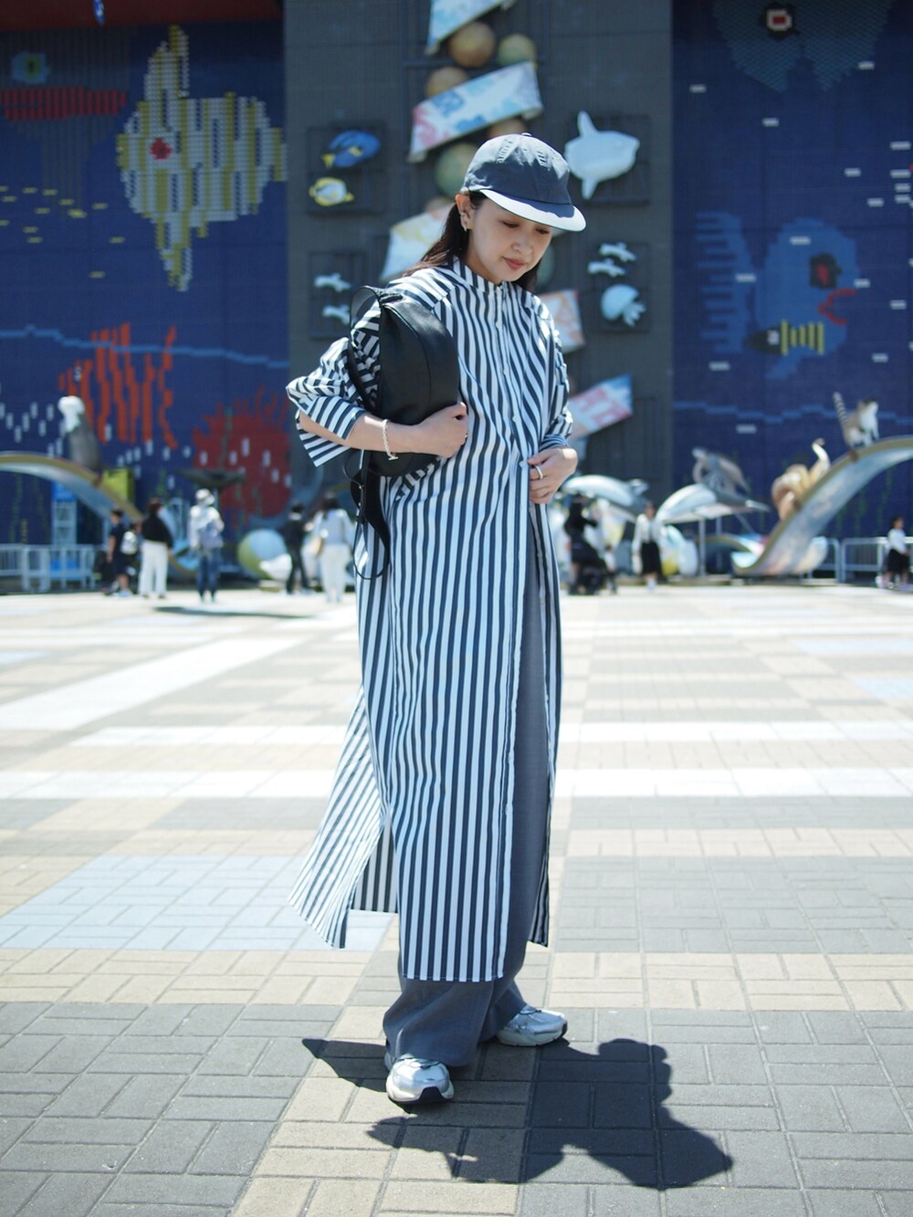 その他のシャツワンピース、グレー系のスラックス、ホワイト系のスニーカーを着用したレディースの春コーディネートの4枚目の写真