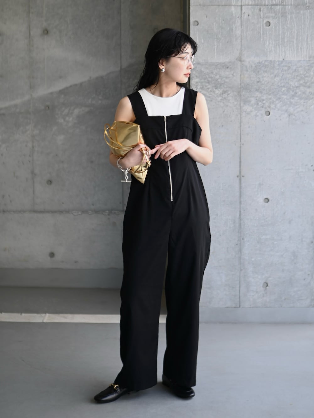 ブラック系のサロペット/オーバーオール、ゴールド系のショルダーバッグ、ブラック系のローファーを着用したレディースの春コーディネートの2枚目の写真
