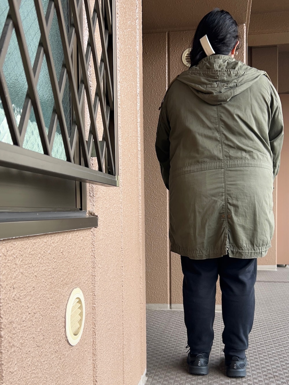 グレー系のスウェット、グリーン系のモッズコート、ブラック系のその他パンツを着用したレディースの冬コーディネートの3枚目の写真