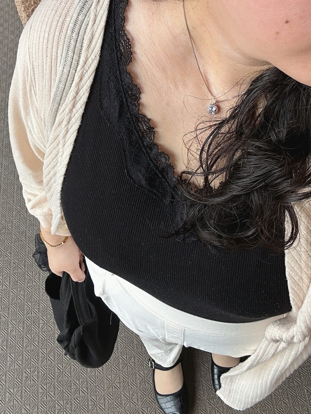 ベージュ系のカーディガン/ボレロ、ブラック系のタンクトップ、ホワイト系のパンツを着用したレディースの秋コーディネートの4枚目の写真