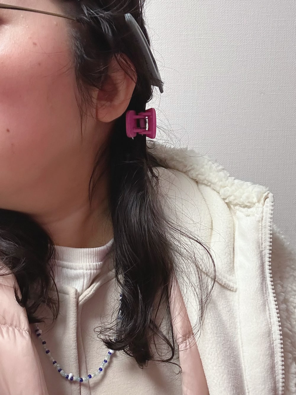 ホワイト系のブルゾン、ピンク系のダウンジャケット/コート、ベージュ系のジャンパースカートを着用したレディースの春コーディネートの3枚目の写真