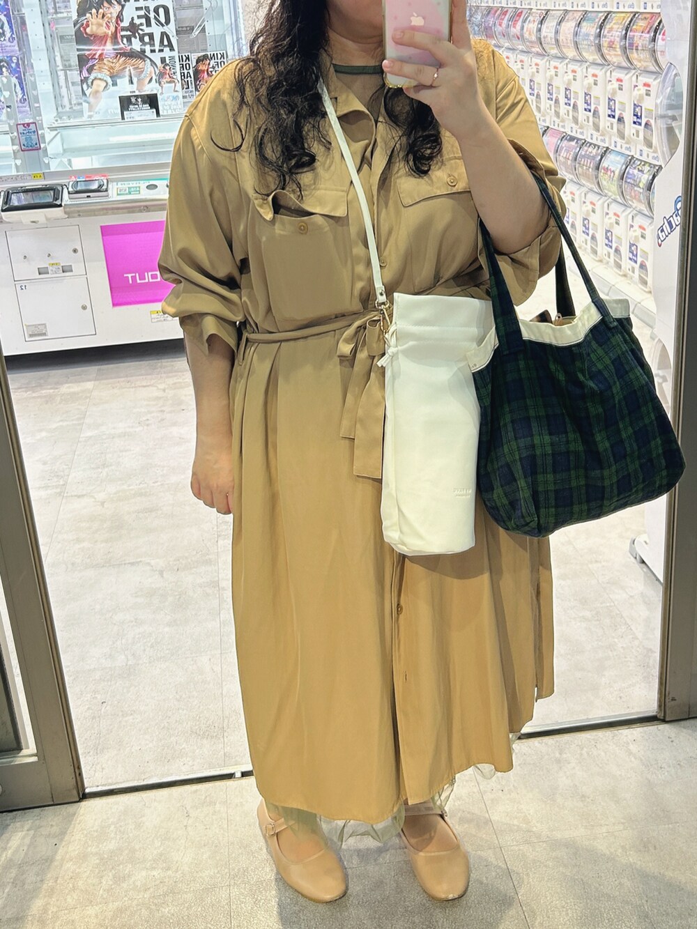 グリーン系のトートバッグ、ホワイト系のショルダーバッグ、グリーン系のワンピースを着用したレディースの秋コーディネートの2枚目の写真