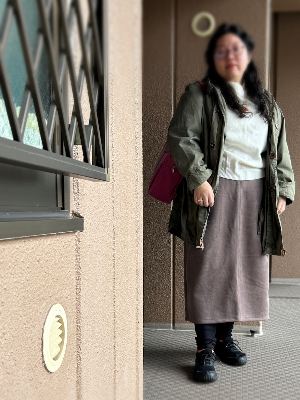 ピンク系のボストンバッグ、ブラウン系のスカート、ホワイト系のニット/セーターを着用したレディースの冬コーディネートの2枚目の写真