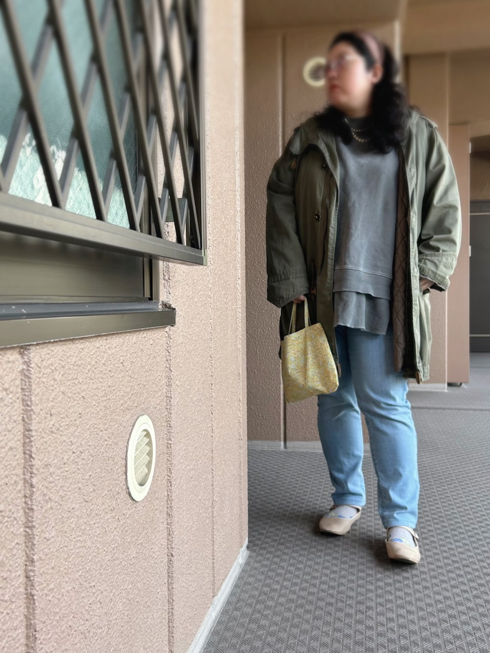 グレー系のスウェット、グリーン系のモッズコート、グリーン系のトートバッグを着用したレディースの春コーディネートの2枚目の写真