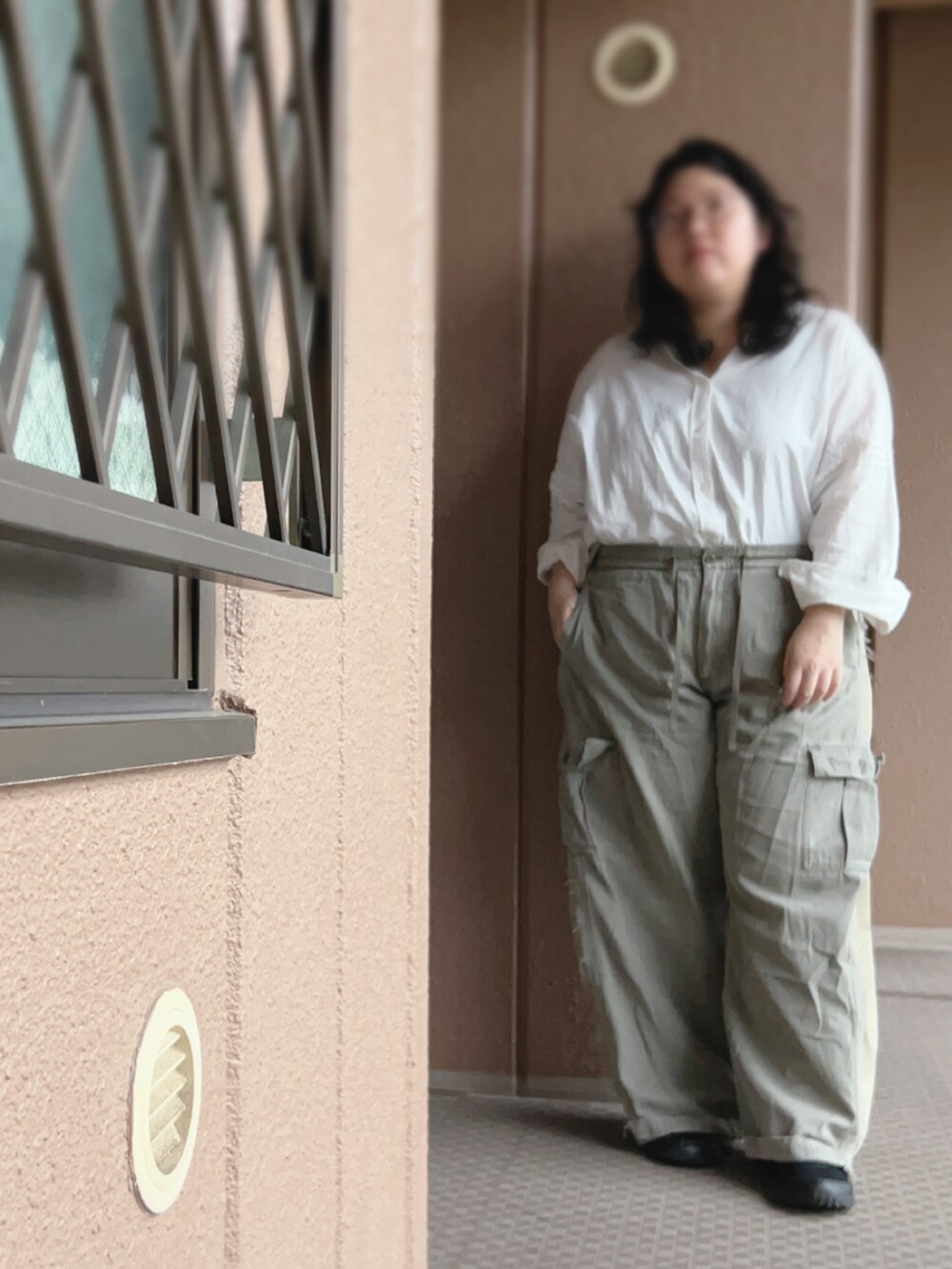 グリーン系のカーゴパンツ、ブラック系のトートバッグ、ブラック系のスニーカーを着用したレディースの夏コーディネートの2枚目の写真