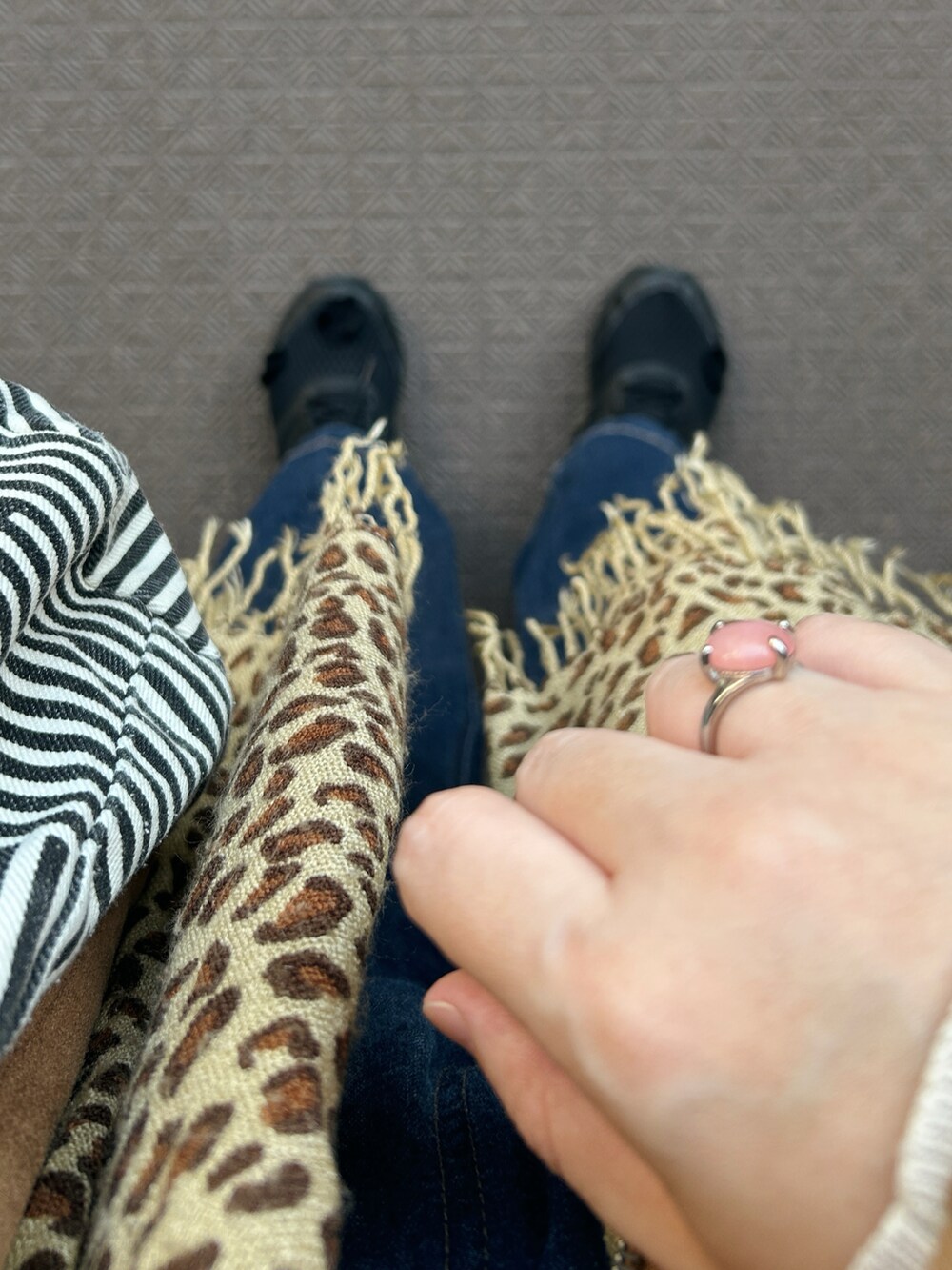 ブラウン系のライダースジャケット、ベージュ系のニット/セーター、ブルー系のデニムパンツを着用したレディースの冬コーディネートの5枚目の写真