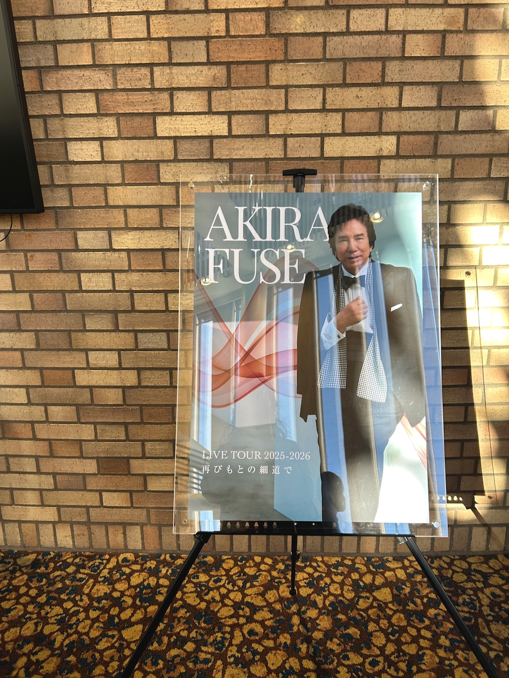 レッド系のワンピース、ベージュ系のカーディガン/ボレロ、ブラック系のトートバッグを着用したレディースの秋コーディネートの5枚目の写真