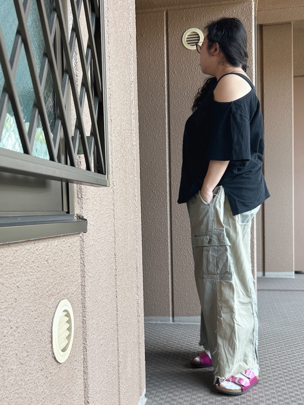 グリーン系のカーゴパンツ、ブラック系のTシャツ/カットソー、ピンク系のサンダルを着用したレディースの秋コーディネートの3枚目の写真