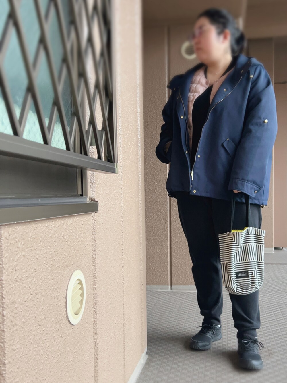 ブラック系のその他パンツ、ブラック系のニット/セーター、ピンク系のダウンジャケット/コートを着用したレディースの冬コーディネートの2枚目の写真