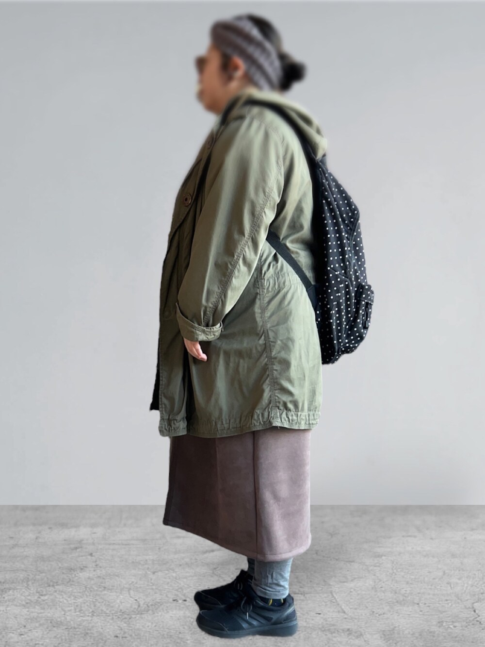 グレー系のスウェット、グリーン系のモッズコート、ブラウン系のスカートを着用したレディースの冬コーディネートの2枚目の写真