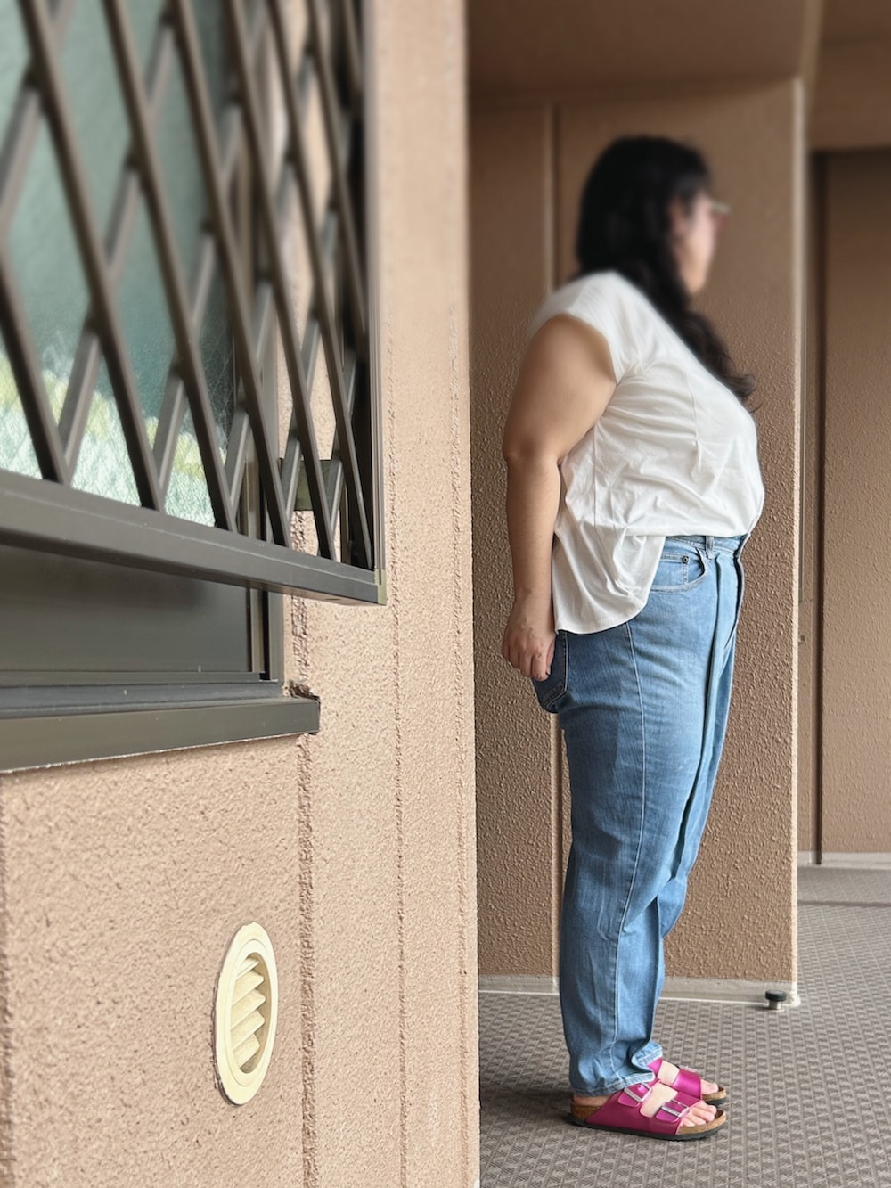 ブルー系のデニムパンツ、ホワイト系のTシャツ/カットソー、ピンク系のサンダルを着用したレディースの秋コーディネートの2枚目の写真