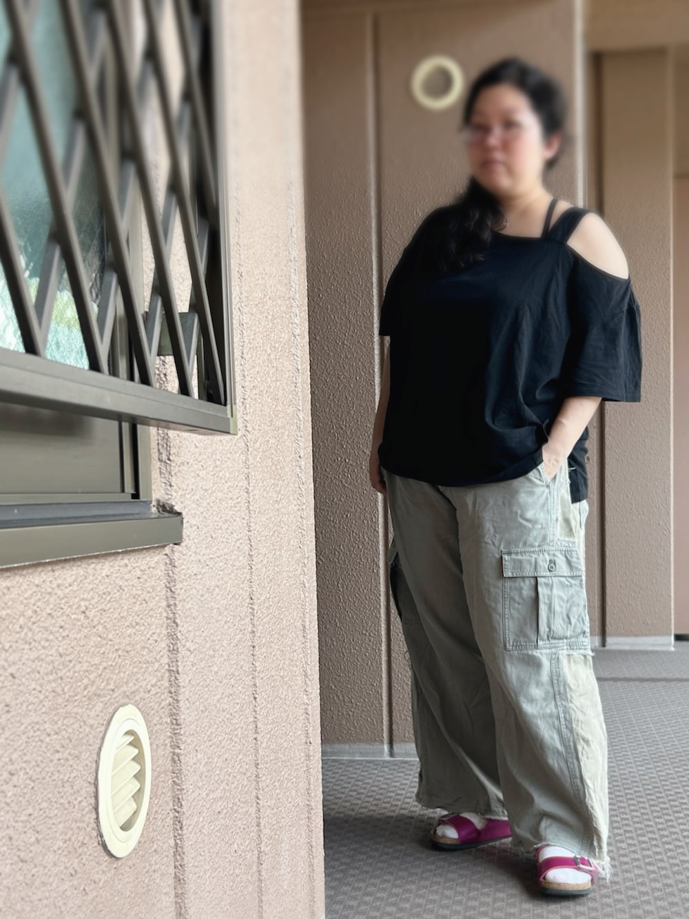 グリーン系のカーゴパンツ、ブラック系のTシャツ/カットソー、ピンク系のサンダルを着用したレディースの秋コーディネートの2枚目の写真