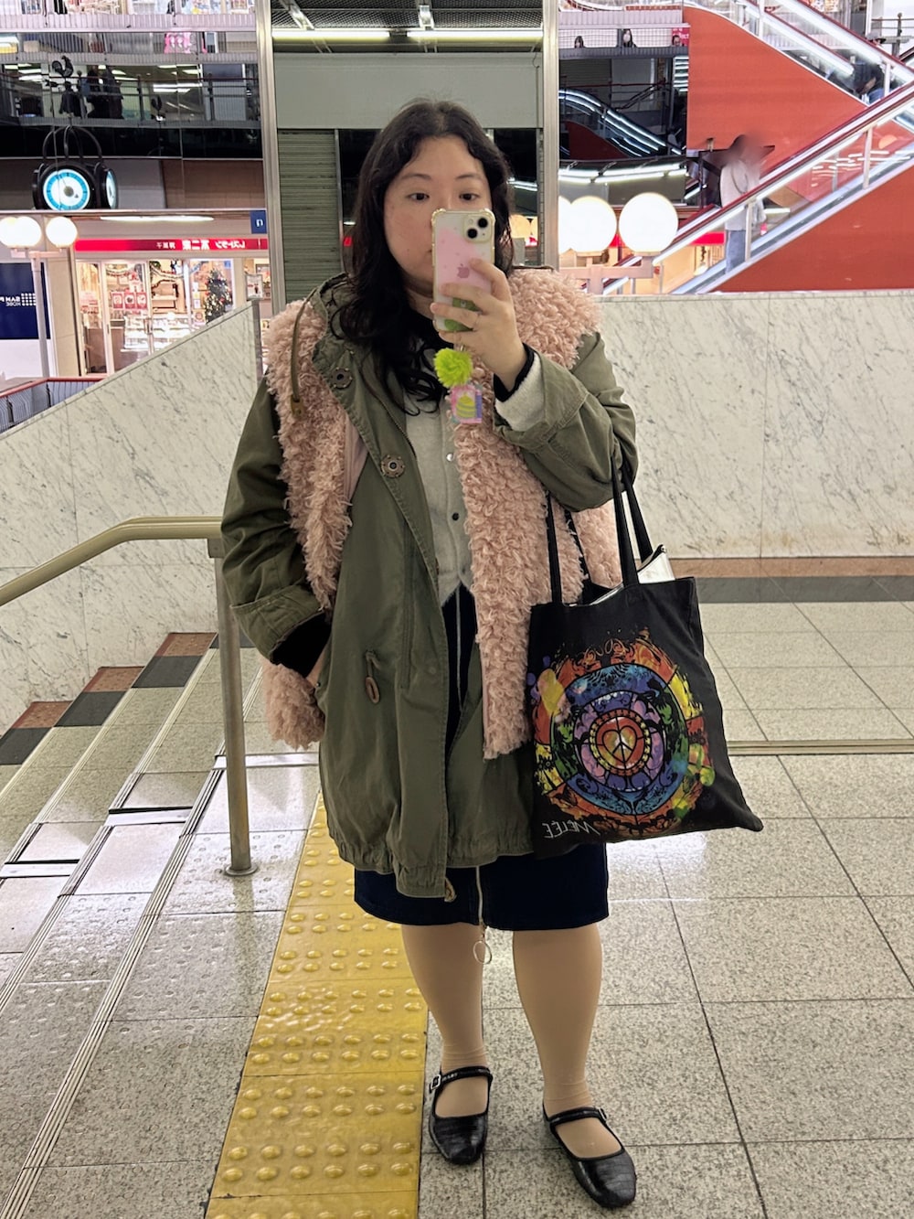 ブラック系のバレエシューズ、ホワイト系のカーディガン/ボレロ、ピンク系のその他アウターを着用したレディースの冬コーディネートの2枚目の写真